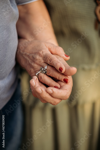 Elderly man in love holds and caresses tender hands of his beautiful woman, couple confesses love and fidelity, close-up