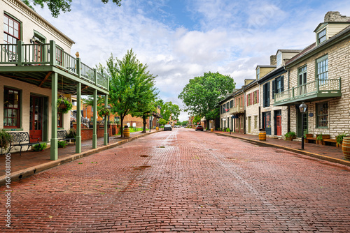 Fototapeta Naklejka Na Ścianę i Meble -  The picturesque brick paved 18th century Main Street of shops through the historic American small town of St. Charles, Missouri.