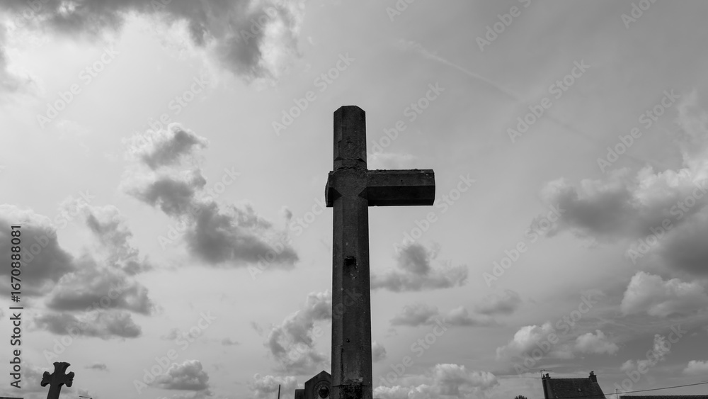 Fototapeta premium Broken stone cross in a historic war cemetery in black and white