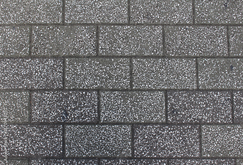 Texture of gray square paving tile. Pattern of sidewalk tiles in the street. Concrete pavers close up background.