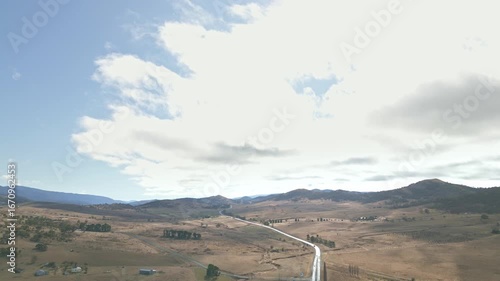 Long road snakes out of town amongst the rolling hills of rural Australia.