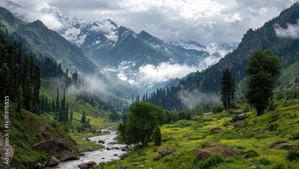 Fototapeta premium Misty valley nestled amongst towering snow-capped mountains. Lush green vegetation and a babbling river wind through the scene
