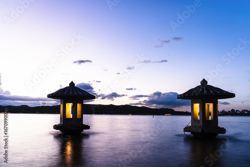 Silhouetted traditional lanterns on West Lake at dusk in Hangzhou, China, wit...