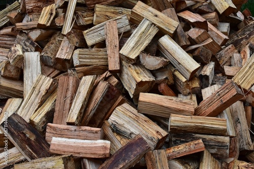 Pile of split log firewood fuel ready for burning in a wood heater, fireplace or combustion stove.
