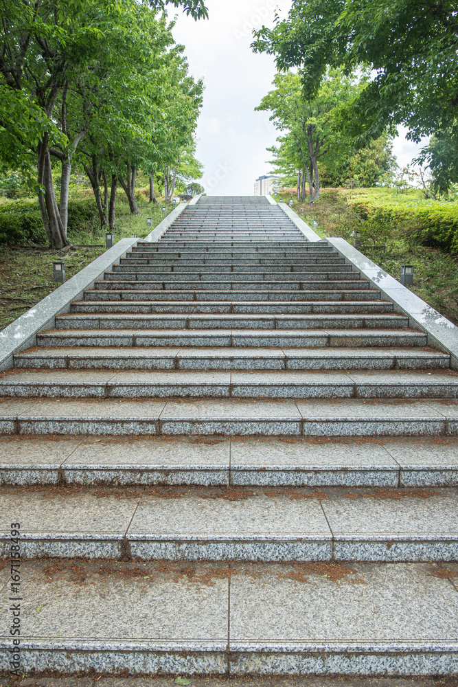 Outdoor stone stairs surrounded by green trees in park setting at Tokyo, Japan Outdoor stone stairs surrounded by green trees in park setting at Tokyo, Japan