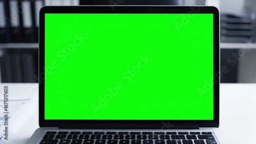 Wallpaper Mural A laptop with a bright green screen is open on a desk, ready for use in a professional office environment Torontodigital.ca