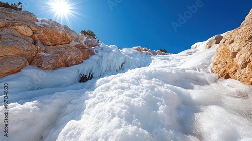 Wallpaper Mural Scenic winter landscape featuring rocks, snow, icicles, and a bright sun against a clear blue sky Torontodigital.ca