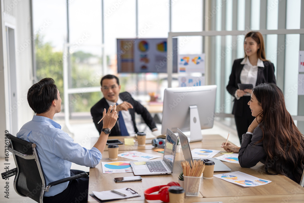 Obraz premium Female executive presents to her team in a contemporary office setting, where an asian businesswoman guides colleagues through strategic planning and business discussion, representing corporate leader