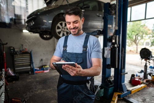 Wallpaper Mural Car mechanic using a digital tablet in a auto repair shop Torontodigital.ca