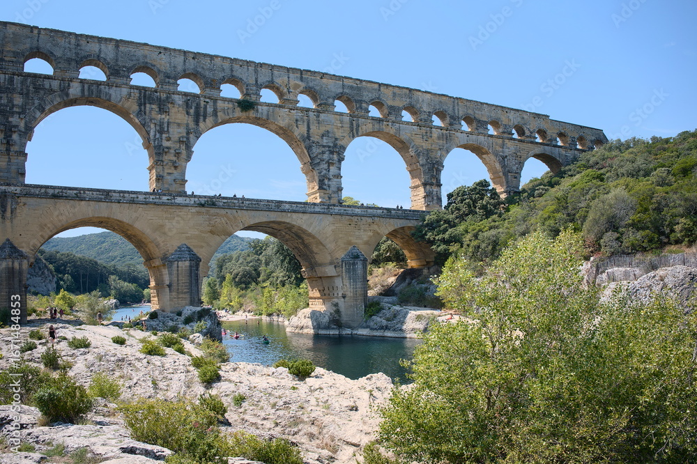 Obraz premium View of the Pont du Gard in summer from the bank of the river