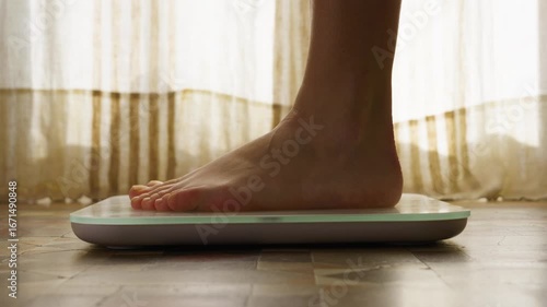 Feet standing on scales, checking BMI weight loss. Measuring body fat overweight barefoot.