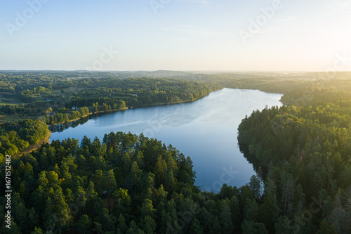 Foto Aerial drone view of a lake surrounded by dense forest and fields in Lithuania, Europe