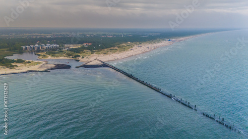 Fototapeta Naklejka Na Ścianę i Meble -  Aerial drone view of the old pier remains in Šventoji, Lithuania, stretching into the Baltic Sea along sandy coastline and popular summer beach resort