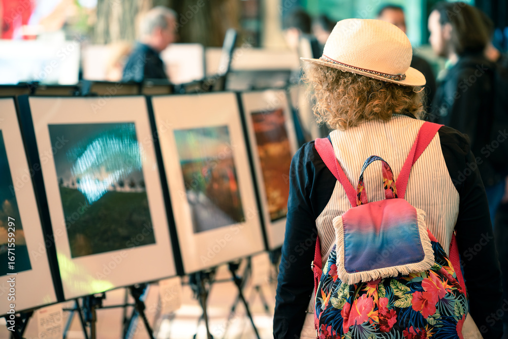 Fototapeta premium Young woman with colorful backpack on art exhibition