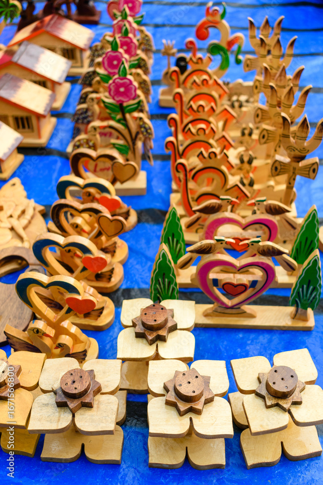 Naklejka premium Colorful Wooden Crafts Featuring Hearts and Flowers at a Market Display