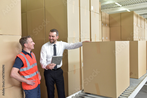 Tableau sur toile Manager and worker in a warehouse in the logistics sector - transport and proces