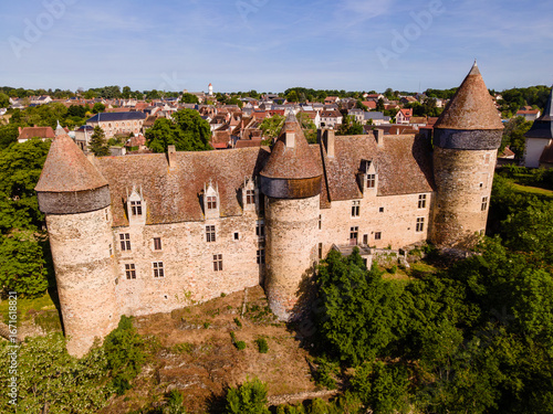 Aerial photograph of Culan Castle in the Cher department, France. The image highlights the medieval fortress, its towers, ramparts, and surrounding landscape, emphasizing the castle’s architecture