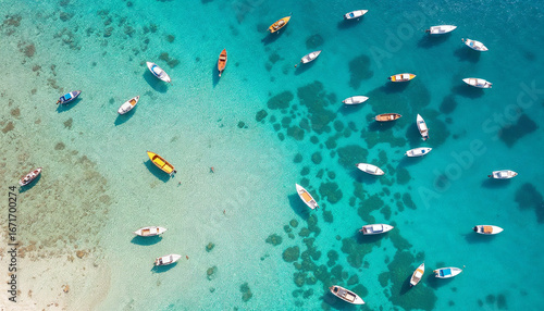 Aerial view of colorful boats on clear turquoise sea with visible coral reefs
