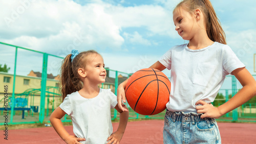 Children playing basketball at sports court during weekend