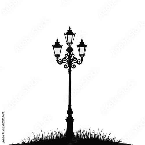 Black silhouette of a vintage triple lamp post on grass