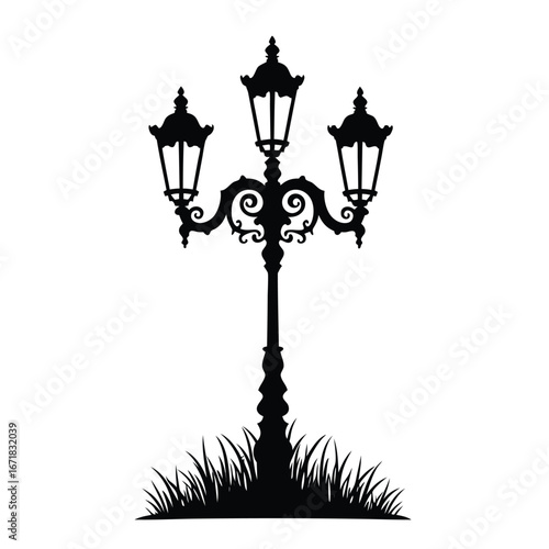 Ornate triple headed black street lamp silhouette with grass
