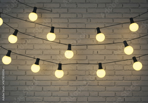 String of glowing round light bulbs hanging against a textured white brick wall, creating a warm and inviting atmosphere.