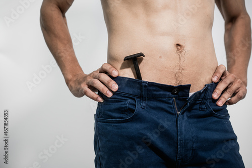 Tableau sur toile Asian man practices intimate grooming with precision, shaving pubic hair in the groin area using professional tools, achieving smooth skin, hygiene, and confidence and masculine body care