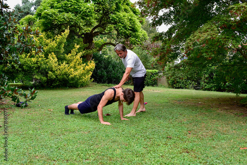 Outdoor fitness training session with push-ups in a garden