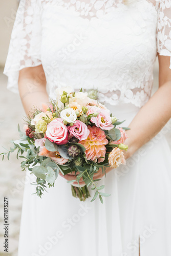 bride holding bouquet of pink roses