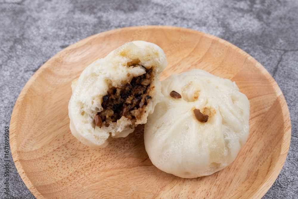 Fototapeta premium The steamed buns with braised pork filling on the plate