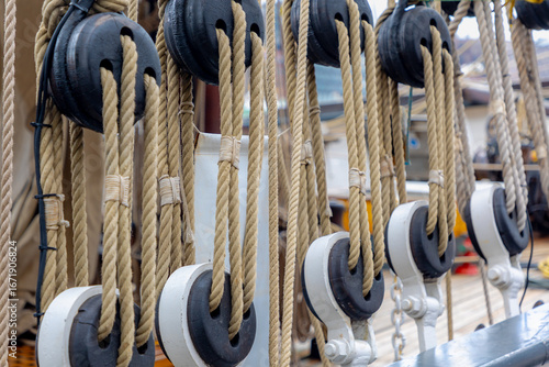 Fotografía Selective focus of a boat poulie with rope lines, Vintage pulley (Katrol) block for Sail, A wheel on an axle or shaft enabling a taut cable or belt passing over the wheel to move and change direction