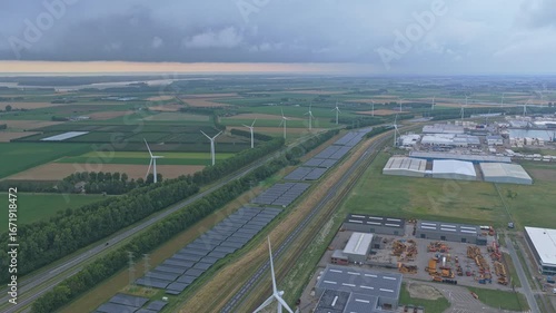 Aerial drone of industrial zone with solar panels and wind turbines, Netherlands