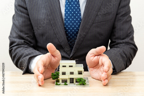 家の模型とビジネスマン