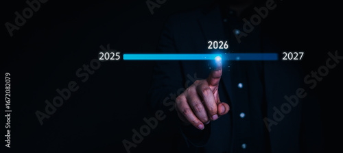 Business target concept with businessman touching glowing 2026 number and dartboard icon, symbolizing goal setting, future planning, business vision, and strategic success roadmap.
