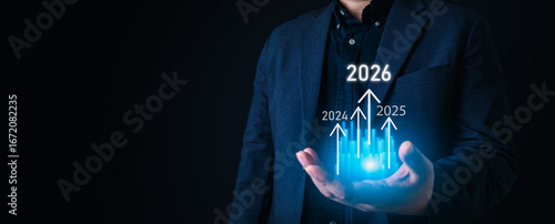 Future growth concept with businessman holding glowing bar chart and arrows pointing to years 2026, symbolizing financial success, economic progress, and strategic planning.