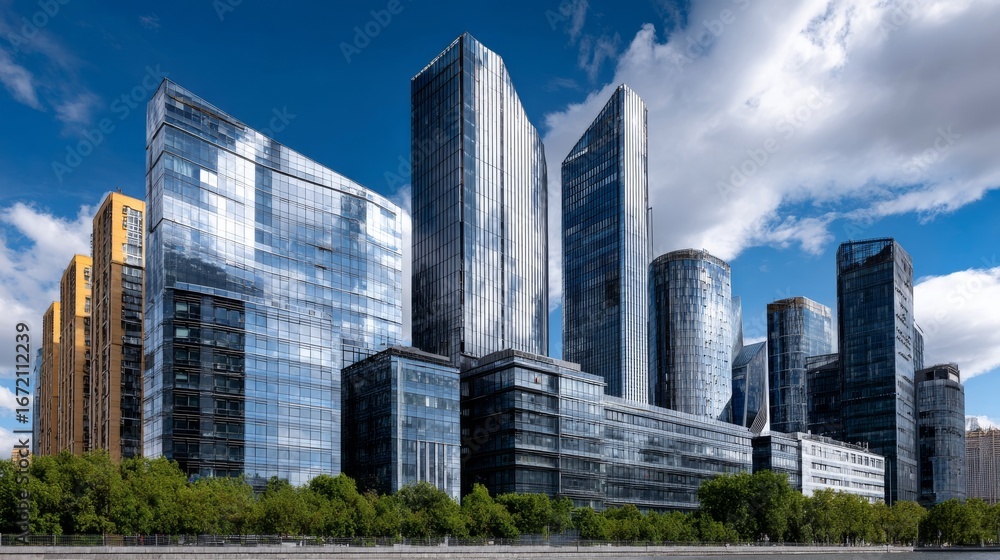 Obraz premium Modern Downtown Skyline Featuring Reflective Glass Buildings Against A Blue Sky With Clouds