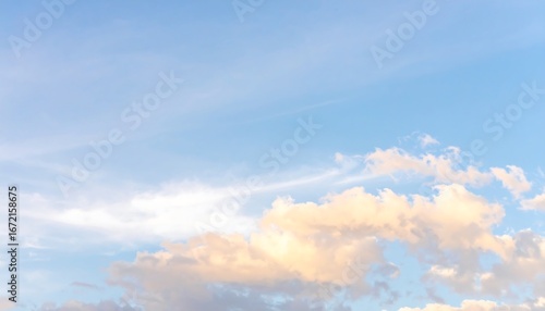 Fototapeta Naklejka Na Ścianę i Meble -  Soft, pastel clouds drift across a pale blue sky