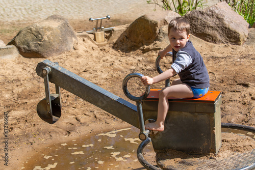 Junge auf dem Wasserspielplatz mit Bagger