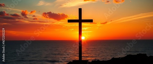 Silhouetted cross at sunset over serene ocean; sky ablaze with vibrant colors,  silhouette,  spiritual