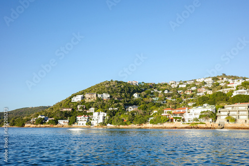 Charming hillside community with modern and traditional houses overlooking the ocean in Knysna. Surrounded by lush greenery and a clear blue sky, scenic coastline captures the beauty of coastal living