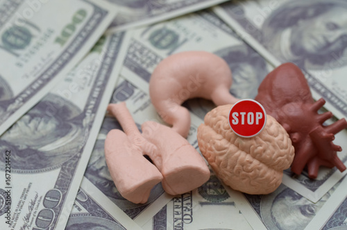 Stop Illegal Organ Trafficking: Conceptual image of a stop sign on human organs and money, symbolizing the fight against the illicit trade of body parts for profit.
