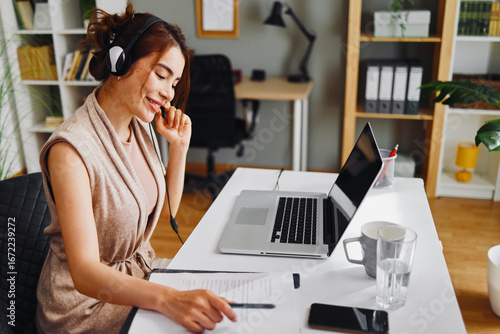 Young businesswoman working from home having a video call and reviewing documents