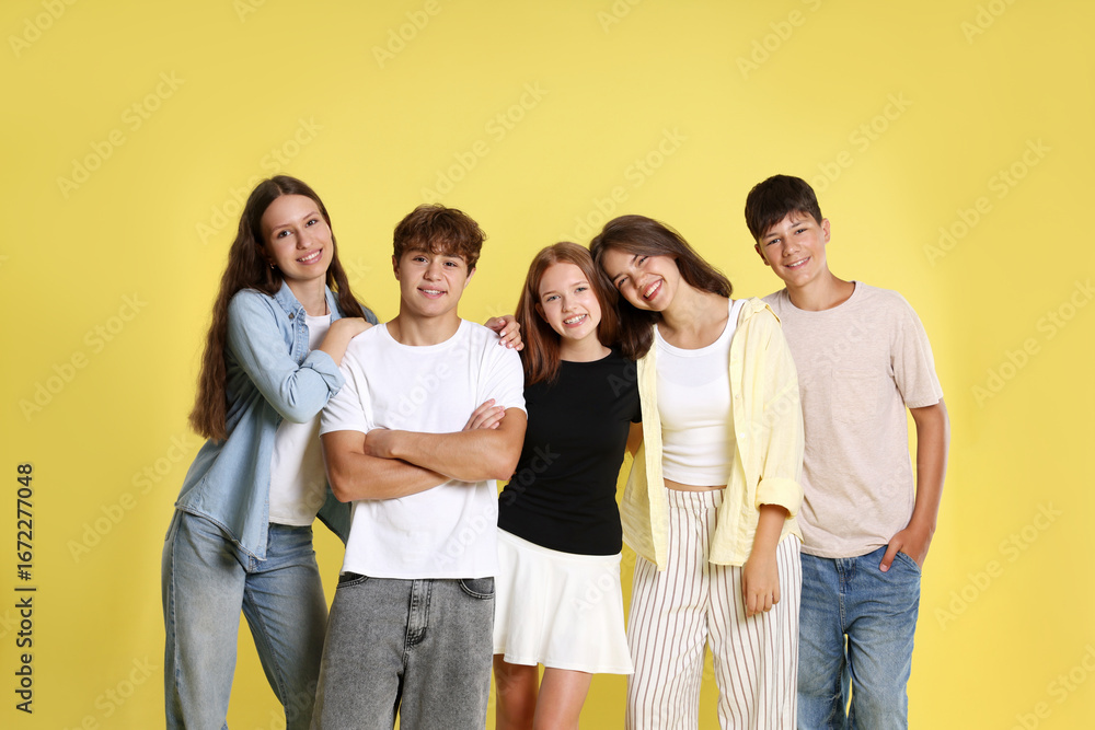 Obraz premium Portrait of happy teenage friends on yellow background