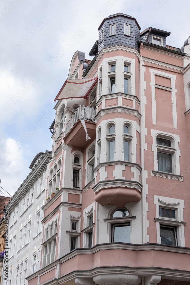Obraz premium Ornate European architecture featuring pastel colored facade, tower windows, and classic design details