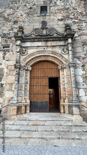 Antique Ornate Stone Archway and Wooden Door of a Historical Church, Intricate Baroque Carvings on a Monumental Entrance, Cultural Heritage and Ancient Architecture Concept
