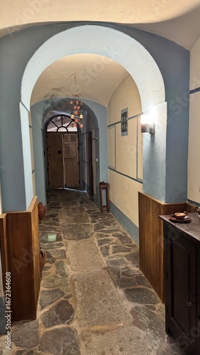 raditional Mediterranean Interior Hallway with Arched Ceiling and Stone Floor: Historical Architecture Reconstruction with Blue and Cream Walls in a Classic European Villa