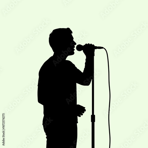 Silhouette of a person singing into a microphone on a stand.