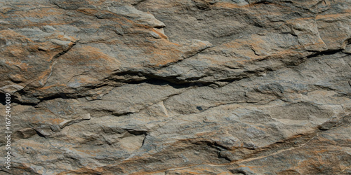 Closeup texture of a rough, layered stone surface with warm brown and gray tones, showcasing natural patterns and geological detail
