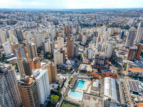 Imagem aérea dos bairros Centro e Cambuí. Prédios comerciais e ruas com muito tráfego de carros e ônibus.