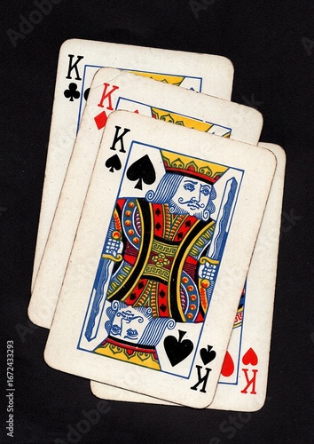Photos Vintage playing cards showing four of the same value isolated on a black background